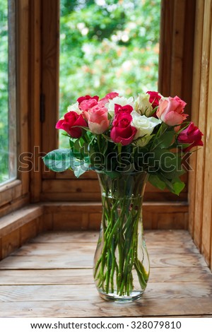 Vase with flowers standing near the window