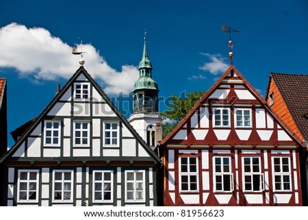 Houses of timber and plaster construction in the old town of Celle, Lower Saxony, Germany dating back to the 16 th century.  Tower of 700 year old St. Marien in the background