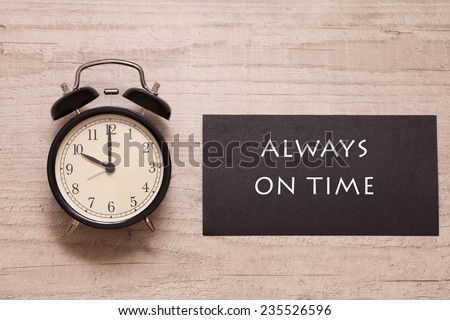 alarm clock and sign indicating to be always on time