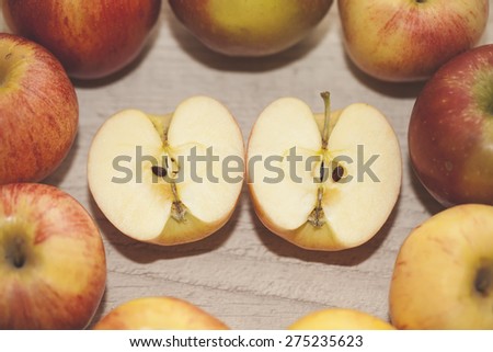 two apple halves in the middle surrounded by red and yellow apples. closeup, selective focus