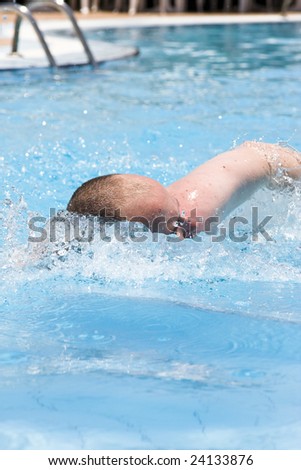 a young man swimming in the swimming pool