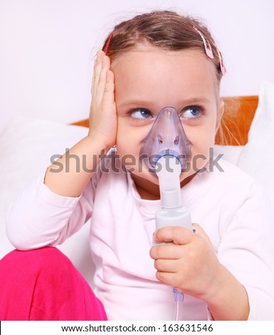 Little girl making aerosol treatment with a rubber masks