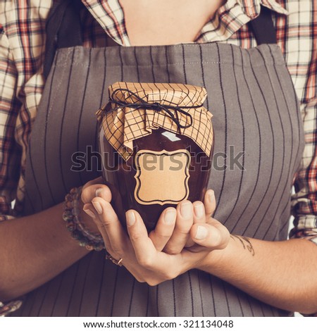Vintage Bank peach jam in the hands of women. Close-up