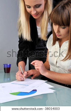 two business women signing papers