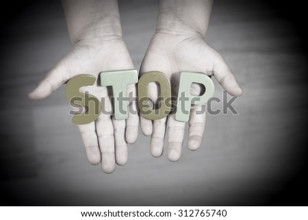 The child asks for help. Written stop letters on the palms