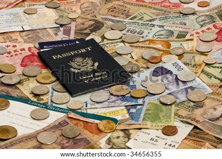 A Passport with ticket stubs on top of mixed foreign money including US, Taiwan, Indian, Hong Kong, Honduran, Malaysian and Korean currency
