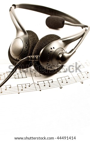 Black headphone isolated on a music composition