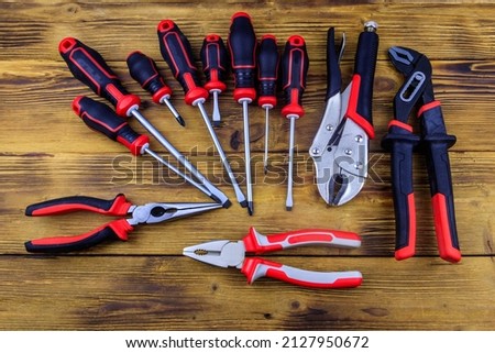 Set of different pliers and screwdrivers on wooden background. Top view Imagine de stoc © 