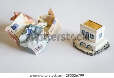 The shot is topical as it represents Greece debt crisis by banknotes and a typical Greek little house. The crumpled banknotes are Greek money crunch and the possibility Greece goes out of Euro zone