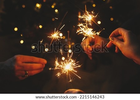 Similar – Foto Bild Menschen verbrennen bengalische Lichter. Wunderkerzen-Hintergrund. Weihnachts- und Neujahrsfeiertage mit Wunderkerzen im Hintergrund.