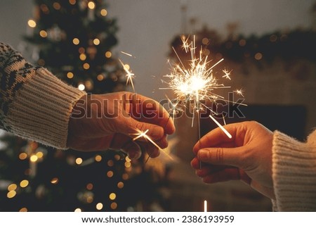 Foto Bild Menschen verbrennen bengalische Lichter. Wunderkerzen-Hintergrund. Weihnachts- und Neujahrsfeiertage mit Wunderkerzen im Hintergrund.