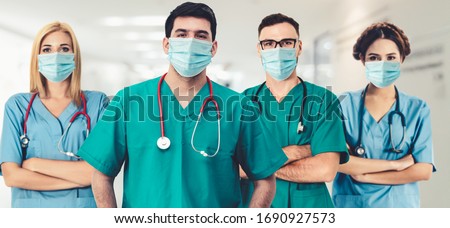 Coronavirus hospital staff - Doctor, surgeon and nurse with medical mask in hospital to fight coronavirus. Epidemic outbreak of coronavirus cause severe hospital occupancy and shortage of staff.
