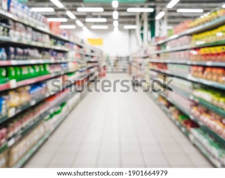 Blurred supermarket aisle with colorful shelves of merchandise. Perspective view of abstract supermarket aisle with copy space in center, can use as background or retail concept