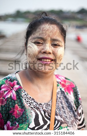Sangklaburi,Thailand-April 05: Unidentified asian girl smile with thanaka powder on face on April 05, 2014 in Mon village,Sangklaburi,Thailand