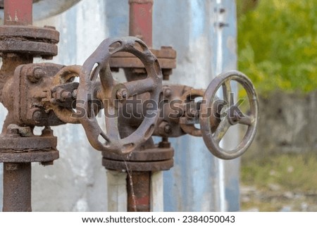 Old rusty steel valve knobs on the wall of a historic water tower.Heavily corroded steel valves of an old historic water installation installed on the wall of an ancient historic water tower. Stock foto © 