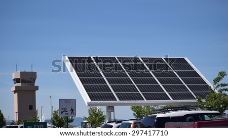 Industrial solar panel with air traffic control tower in background
