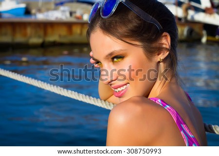 Summer close up fashion portrait of young hipster girl,positive surprised emotions,smile,on the amazing city sea view terrace.Travel tourism and people concept.Portrait close up young beautiful woman