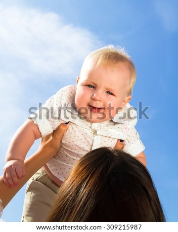 Little cute baby outdoor.A cute child outside at sky background (copy space).Adorable toddler boy in the park.Summer portrait of happy baby girl infant outdoors at park.Baby wearing white shirt.
