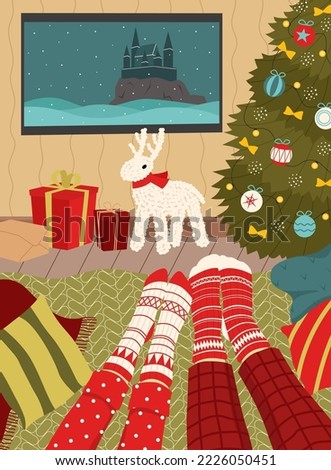 Leisure during the Christmas holidays. Couple in christmas socks watching a movie. Cozy interior.