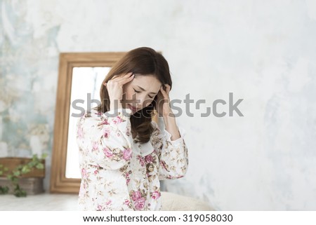 Woman suffering from a stiff neck and headaches