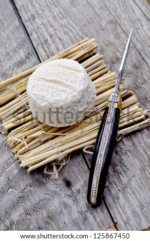 French cheese on a straw mat with decorative knife