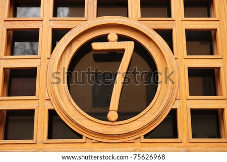 Entrance with the street number seven on the door made of wood