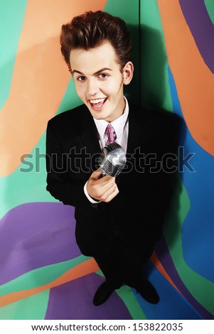 Singing Man with Retro Microphone on a colored background. Vintage Style. Song.