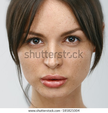 Close-up face portrait of young woman without make-up. Natural image without retouching w/shallow depth of field.
