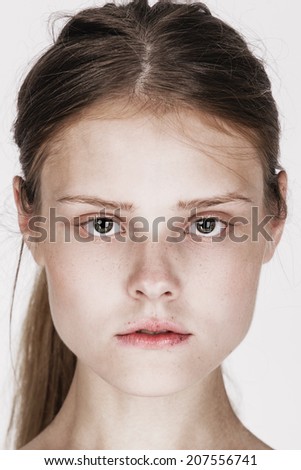 Close-up face portrait of young woman without make-up. Natural image without retouching w/shallow depth of field.