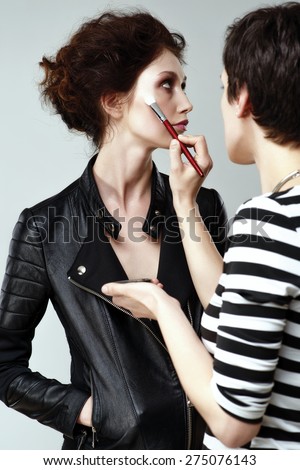 Making up the models face - professional makeup artist working