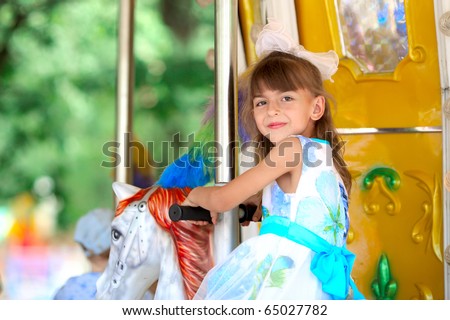 pretty girl riding a merry go round