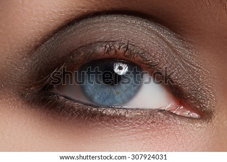 Closeup image of closed woman eye with beautiful bright makeup, smoky eyes
