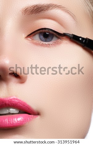 Beautiful woman with bright make up eye with sexy black liner makeup. Fashion arrow shape. Chic evening make-up