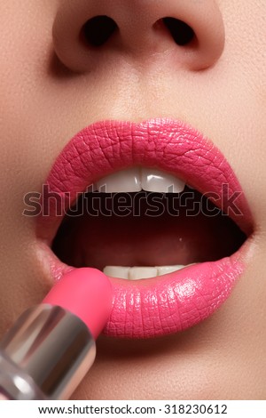 Woman painted pink lips. Beauty lips make-up. Perfect skin, full lips. Retro make up. Professional make-up artist applying sexy lips makeup. Fashion makeup