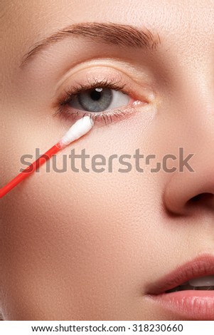 Skin care woman removing face makeup with cotton swab. Skin care concept. Caucasian model with perfect skin. Beauty & Spa.