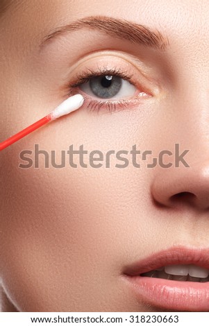 Skin care woman removing face makeup with cotton swab. Skin care concept. Caucasian model with perfect skin. Beauty & Spa.