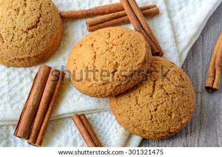 Oatmeal cookies and cinnamon sticks on white background