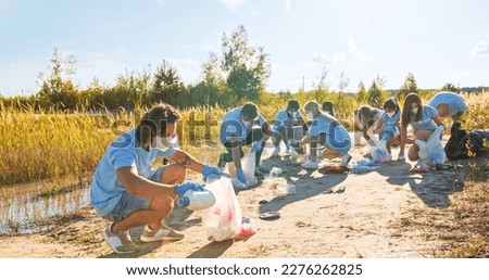 Similar – Image, Stock Photo Coronavirus garbage. Volunteers collecting used disposable medical masks and gloves near the bus stop and along the highway. The problem of environmental pollution during a pandemic COVID-19