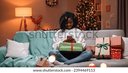 Similar – Image, Stock Photo Young woman in christmassy clothes looks smiling at a christmas present