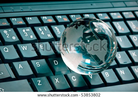 small glass globe on a laptop keyboard