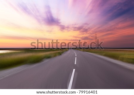 Empty blurry country road under sunset