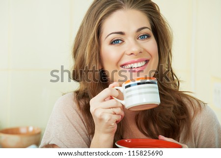 Portrait of smiling  woman holding coffee cup at the kitchen interior. Close up smiling female face.