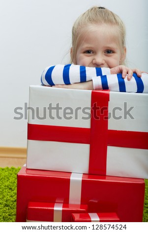 Little girl with white hair and many gifts . Seat on floor.