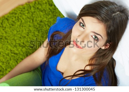Woman seating on floor . Female model indoor portrait. Looking up.