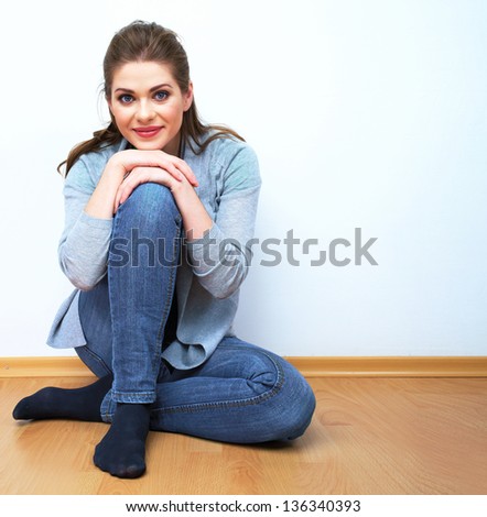 Young woman seat on floor, isolated portrait of beautiful model