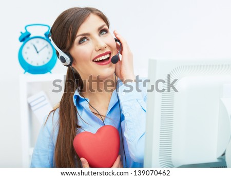 Portrait of call center smiling operator with phone headset isolated on white office background hold red heart. Help concept.