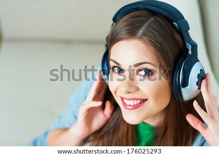 Girl with headphones listening music at home. Female model.