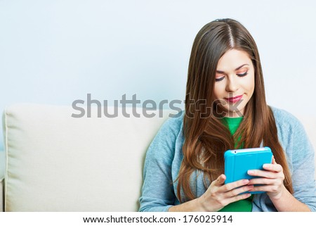 Young woman working with tablet pc, pad at home. Female model portrait.