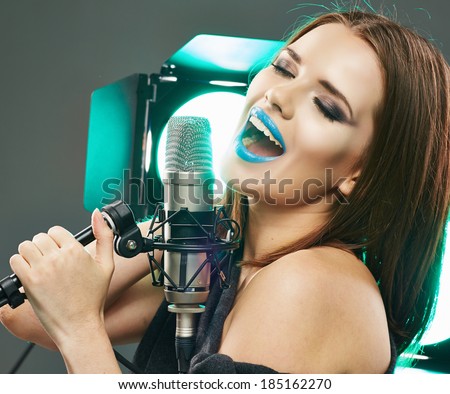 Beautiful woman with microphone. Long hair, blue lips.