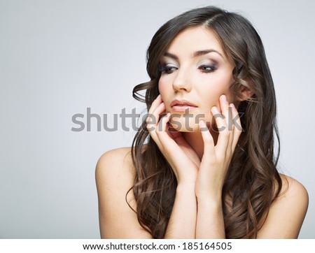 Woman beautiful face portrait. Skin care style face hand touching. Female model studio posing.